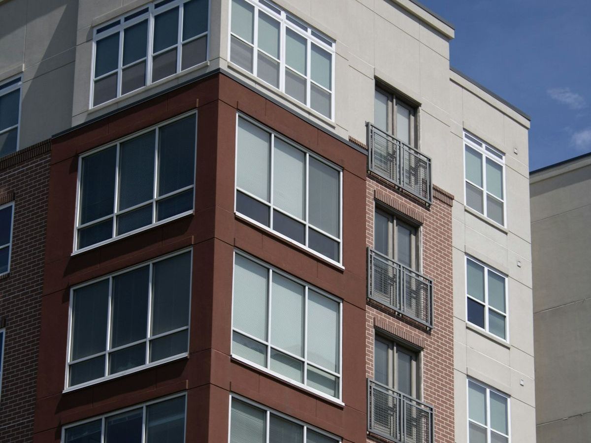 Corner of a modern brick apartment building with large windows